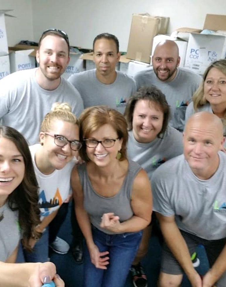 group of people in gray shirts taking a selfie together