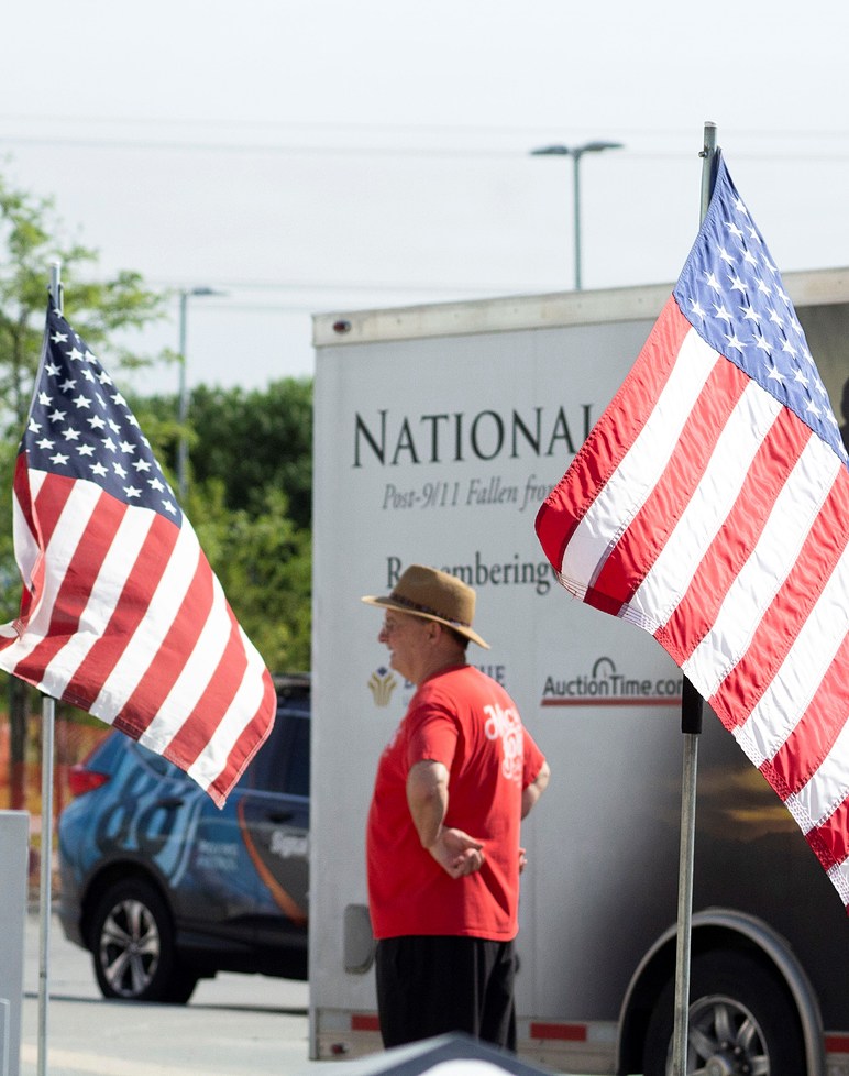 person standing between two American flags